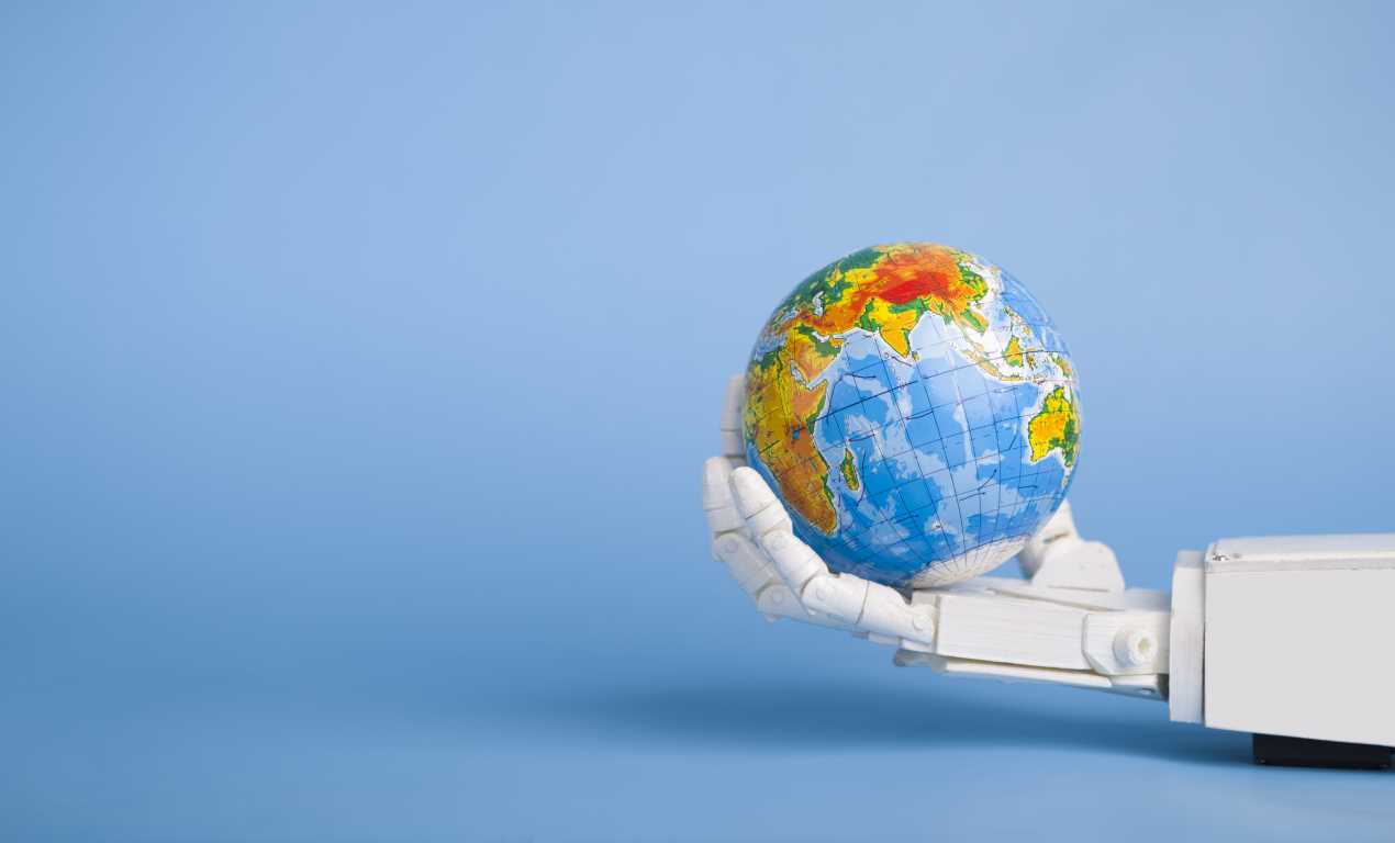 Earth globe in robotic hand, blue panorama background